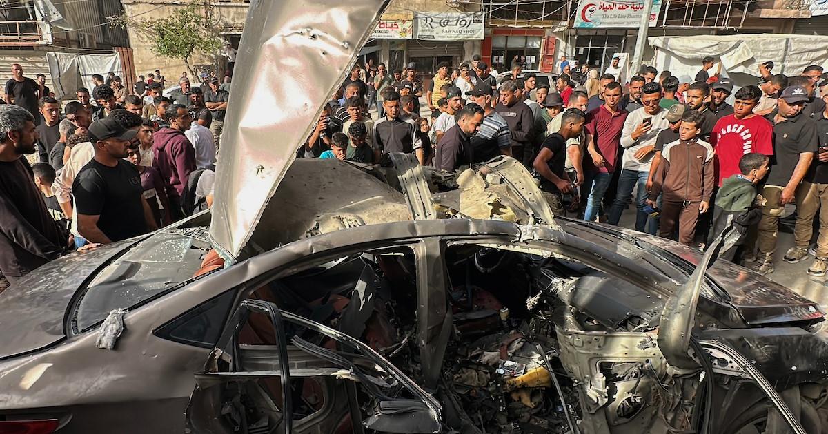 فلسطينيون يتجمعون في موقع غارة إسرائيلية استهدفت مركبة في مدينة غزة