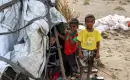 صورة التُقطت في 19 آب-أغسطس لأطفال يقفون خارج خيمة في مخيم للنازحين تضرر من السيول في منطقة الجراحي التي دمرتها الحرب بمحافظة الحديدة غرب اليمن - خالد زياد -اف ب-ارشيف.webp