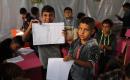أطفال فلسطينيون نازحون يحضرون درسًا داخل خيمة تُستخدم كفصل دراسي مؤقت في ملجأ بدير البلح.jpg