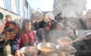 يتلقى الفلسطينيون، بمن فيهم الأطفال، الذين يعانون من صعوبة الحصول على الغذاء بسبب الهجمات الإسرائيلية المستمرة، وجبات ساخنة توزعها إحدى الجمعيات الخيرية في مخيم النصيرات للاجئين وسط قطاع غزة، 5 يناير/كانون الثاني 2026. تصوير: أحمد إبراهيم