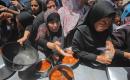 نساء وأطفال فلسطينيون نازحون ينتظرون الحصول على وجبات طعام وزعتها منظمات خيرية في مدينة غزة، في 22 يونيو/حزيران 2026.تصوير: حسن الجدي