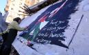 فنانون فلسطينيون يرسمون جدارية لمغني الراب الأمريكي ماكليمور على جدار مبنى دمرته الحرب في مدينة غزة، في 17 سبتمبر/أيلول 2026. تصوير: عبد الله أبو الخير