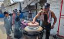 الفلسطيني مازن الدوش يُعدّ الخبز على صاج بدائي بين أنقاض المباني المدمرة في خان يونس، جنوب قطاع غزة، 9 تشرين الأول/أكتوبر 2026. (تصوير: طارق محمد)