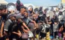يتجمع فلسطينيون نازحون لتلقي وجبات ساخنة من مطبخ خيري، يُوصف بأنه آخر مطبخ عامل في منطقة المواصي بخان يونس، 2 أكتوبر/تشرين الأول 2026. (صورة: طارق محمد)