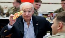 الرئيس الأميركي جو بايدن يأكل البيتزا أثناء اجتماعه مع جنود الجيش الأميركي في بولندا، 25 آذار/مارس 2022. (رويترز)