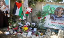 امرأة فلسطينية تلتقط صورا في مكان استشهاد مراسلة الجزيرة شيرين أبو عاقلة في جنين، 17 أيار/مايو 2022. (رويترز / رنين صوافطة)