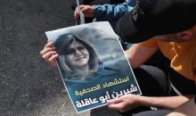 فلسطيني يحمل ملصقًا للشهيدة شيرين أبو عاقلة في مدينة الخليل. (أ ف ب).jpeg