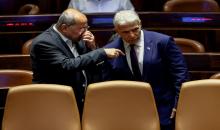عضو الكنيست ورئيس القائمة العربية المشتركة أحمد الطيبي يتحدث إلى وزير الخارجية الإسرائيلي يائير لابيد في الكنيست، 22 حزيران/يونيو 2022. (رويترز)