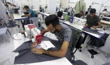 عمال فلسطينيون يعملون في مصنع للخياطة خلال جولة وزارة الاقتصاد في مدينة غزة