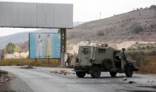 متظاهرون يحملون الأعلام الفلسطينية ويحرقون الإطارات على حاجز حوارة احتجاجا على استمرار الحصار الإسرائيلي على مدينة نابلس.jpg