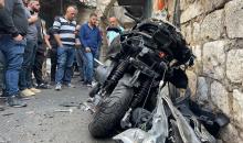 فلسطينيون يتجمعون حول دراجة نارية مدمرة، عقب استشهاد الشاب تامر كيلاني، في البلدة القديمة في نابلس.jpg