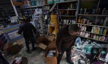 مواطنون يتفقدون آثار الدمار الذي لحق بصيدلية قريبة من مكان العملية التي نفذتها قوات الاحتلال الاسرائيلي.jpg