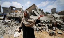 صورة التقطت في 15 أيا/مايو 2023 في بيت لاهيا وتظهر فيها الفلسطينية نجاح نبهان (56 عاما) وهي تتحدث وتشير إلى أنقاض المبنى السكني الذي كانت تقطنه هي وعائلتها قبل أن تقصفه إسرائيل  - محمود الهمص / ا ف ب