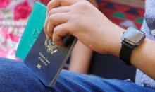 هاني المدهون فلسطيني يحمل جواز سفره الأمريكي بينما يجلس في منزله ببيت لاهيا في شمال غزة يوم الأربعاء. تصوير: محمد سالم - رويترز