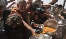 فلسطينيون يتزاحمون للحصول على الطعام من أحد المطابخ الخيرية بقطاع غزة.webp