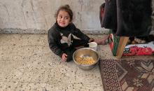 امرأة فلسطينية تأوي مع أطفالها داخل مدرسة مدمرة قرب خط التماس الأصفر شرق خان يونس