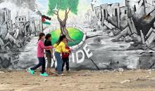 يرسم فنانون فلسطينيون جدارية وسط أنقاض المباني المدمرة في خان يونس، جنوب قطاع غزة.jpg