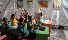 أطفال فلسطينيون نازحون يحضرون درسًا داخل خيمة تُستخدم كفصل دراسي مؤقت في ملجأ بدير البلح (7).jpg