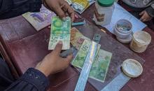 الفلسطينية منال السعيداني تُصلح أوراقًا نقدية قديمة ومهترئة في ظل نفاد العملة الصعبة في قطاع غزة (18).jpg