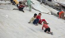 أطفال فلسطينيون يمشون على أسطح منازلهم المدمرة جراء الحرب الإسرائيلية في خان يونس (4).jpg