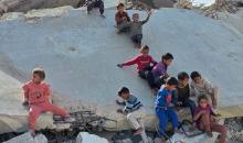 أطفال فلسطينيون يمشون على أسطح منازلهم المدمرة جراء الحرب الإسرائيلية في خان يونس (11).jpg