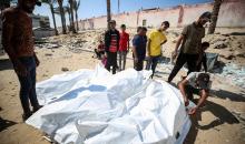 عمال المشرحة يُفرّغون جثث فلسطينيين كانوا محتجزين لدى إسرائيل، بعد نقلها بسيارات الهلال الأحمر وشاحنات التبريد، إلى مستشفى ناصر في خان يونس جنوب قطاع غزة في 16 أكتوبر/تشرين الأول 2025