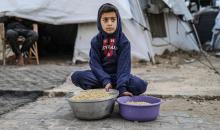 يصطفّ  فلسطينيون لتلقّي الطعام من مطبخ خيري في تجمع للنازحين بمخيم النصيرات للاجئين، وسط قطاع غزة. ١٧ ديسمبر/كانون الأول ٢٠٢٥. تصوير: رمزي أبو عامر / (apa)