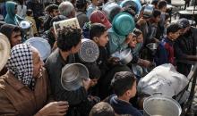 يصطفّ  فلسطينيون لتلقّي الطعام من مطبخ خيري في تجمع للنازحين بمخيم النصيرات للاجئين، وسط قطاع غزة. ١٧ ديسمبر/كانون الأول ٢٠٢٥. تصوير: رمزي أبو عامر / (apa)