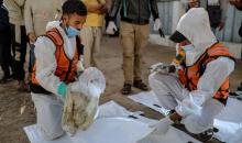 منقذون ومتطوعون فلسطينيون يستخرجون جثث ضحايا الحرب من مقبرة مؤقتة داخل المستشفى العربي المعمداني بمدينة غزة، ليعاد دفنها