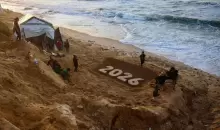 منحوتة رملية للفنان يزيد أبو جراد تمثل العام المقبل حيث يستعد الفلسطينيون النازحون لاستقبال العام الجديد في دير البلح بوسط قطاع غزة (أ.ف.ب).webp