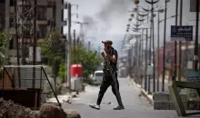 أحد عناصر الجماعات المسلحة الدرزية يقف عند نقطة تفتيش عقب الاشتباكات الطائفية التي وقعت الأسبوع الماضي في مدينة السويداء ذات الأغلبية الدرزية في سوريا، الجمعة 25 يوليو-تموز 2025 AP Photo-Omar Sanadiki.webp