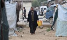 يتجمع الفلسطينيون لتلقي مياه الشرب مجانًا في مخيم البريج للاجئين، في ظل تفاقم أزمة نقص المياه وتدهور البنية التحتية، 21 ديسمبر/كانون الأول 2025. صورة: رمزي أبو عامر