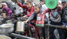 يصطفّ  فلسطينيون لتلقّي الطعام من مطبخ خيري في تجمع للنازحين بمخيم النصيرات للاجئين، وسط قطاع غزة. ١٧ ديسمبر/كانون الأول ٢٠٢٥. تصوير: رمزي أبو عامر / (apa)