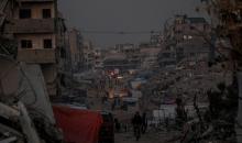 يعيش الفلسطينيون حياتهم اليومية ليلاً في خيام نصبت فوق أنقاض المباني المدمرة في حي الشيخ رضوان وسط مدينة غزة، 5 ديسمبر/كانون الأول 2025.تصوير: عمر أشتوي