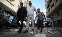 فلسطينيون يمرون أمام مبنى سكني تضرر جراء غارة عسكرية إسرائيلية أسفرت عن سقوط عدد من الضحايا في مدينة غزة، السبت 31 يناير/كانون الثاني 2026. صورة: عمر أشتوي