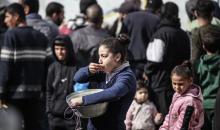 أطفال فلسطينيون ينتظرون وجبة ساخنة، توزعها إحدى المنظمات الخيرية، في ظل استمرار أزمة الغذاء بسبب محدودية المساعدات الإنسانية في مخيم النصيرات للاجئين وسط قطاع غزة، في 10 يناير/كانون الثاني 2026. صورة: معز صالحي