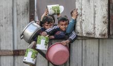 أطفال فلسطينيون ينتظرون وجبة ساخنة، توزعها إحدى المنظمات الخيرية، في ظل استمرار أزمة الغذاء بسبب محدودية المساعدات الإنسانية في مخيم النصيرات للاجئين وسط قطاع غزة، في 10 يناير/كانون الثاني 2026. صورة: معز صالحي