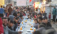 يتجمع فلسطينيون نازحون لتناول وجبة الإفطار وسط أنقاض المباني المدمرة في مدينة غزة، خلال شهر رمضان المبارك، في 25 فبراير/شباط 2026. صورة: عمر أشتوي