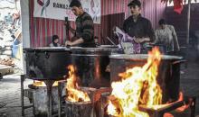 يتجمع فلسطينيون نازحون لتناول وجبة إفطارهم الرمضانية في مطبخ خيري بمخيم النصيرات للاجئين وسط قطاع غزة، في 24 فبراير/شباط 2026. ويواجه النازحون ظروفًا معيشية قاسية نتيجة انعدام الدخل ونقص المساعدات الإنسانية. (صورة: رمزي أبو عامر / apaimages)