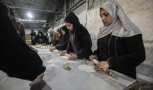 نساء فلسطينيات، زوجات شهداء الحرب، يُجهّزن الخبز لتوزيعه على العائلات النازحة والمحتاجة في مخيم البريج للاجئين وسط قطاع غزة خلال شهر رمضان، في مشهد يُجسّد روح التضامن والصمود في ظلّ الظروف الإنسانية الصعبة، فبراير/شباط 2026. تصوير: معز صالحي