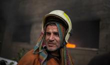 طواقم الدفاع المدني ومتطوعون من المواطنين أثناء محاولة إخماد حريق اندلع في مستودع تابع لمنظمة إغاثة في حي الرمال، غرب مدينة غزة، في 13 فبراير/شباط 2026. صورة: عمر أشتوي