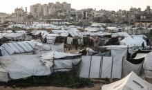 عائلة فلسطينية نازحة تتناول فطورها خلال شهر رمضان داخل خيمة متداعية في مخيم النصيرات للاجئين وسط قطاع غزة. تواجه العائلات النازحة ظروفًا معيشية قاسية نتيجة الحرب، مع انعدام الدخل ونقص حاد في المساعدات الإنسانية، 26 فبراير/شباط 2026. تصوير: معز صالحي