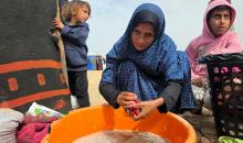 هالة عوض (48 عاما) كفيفة فقدت زوجها في هجوم إسرائيلي، تعيش مع أطفالها السبعة في خيمة مؤقتة غرب خان يونس، وتعيلهم بمفردها رغم إعاقتها البصرية. تصوير: طارق محمد