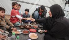 عائلة فلسطينية نازحة تتناول فطورها خلال شهر رمضان داخل خيمة متداعية في مخيم النصيرات للاجئين وسط قطاع غزة. تواجه العائلات النازحة ظروفًا معيشية قاسية نتيجة الحرب، مع انعدام الدخل ونقص حاد في المساعدات الإنسانية، 26 فبراير/شباط 2026. تصوير: معز صالحي