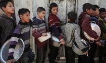 تجمعت عائلات فلسطينية نازحة لتلقي وجبات مجانية من مطبخ خيري في مخيم النصيرات للاجئين، وسط تعليق عمليات منظمة