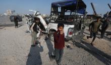 يتفقد فلسطينيون موقع هجوم إسرائيلي على سيارة شرطة قرب مدخل بلدة الزويدة وسط قطاع غزة، في 15 مارس/آذار 2026.