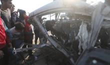 يتفقد فلسطينيون موقع هجوم إسرائيلي على سيارة شرطة قرب مدخل بلدة الزويدة وسط قطاع غزة، في 15 مارس/آذار 2026