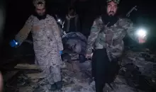 رجال أمن يحملون جثة أحد الضحايا (الفرنسية).webp