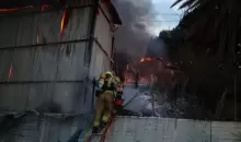 رجال الإطفاء يخمدون حريقا في موقع ضربة على أطراف تل أبيب في 13 مارس آذار 2026 (الفرنسية).webp