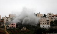 يتصاعد الدخان والغبار بينما يقوم الجيش الإسرائيلي بهدم منزل الأسير  عزمي أبو حليل، المتهم بتنفيذ هجوم عام 2024 على الإسرائيليين، في قريته دورا، غرب مدينة الخليل، في 14 مارس/آذار 2026. صورة: مأمون وزواز